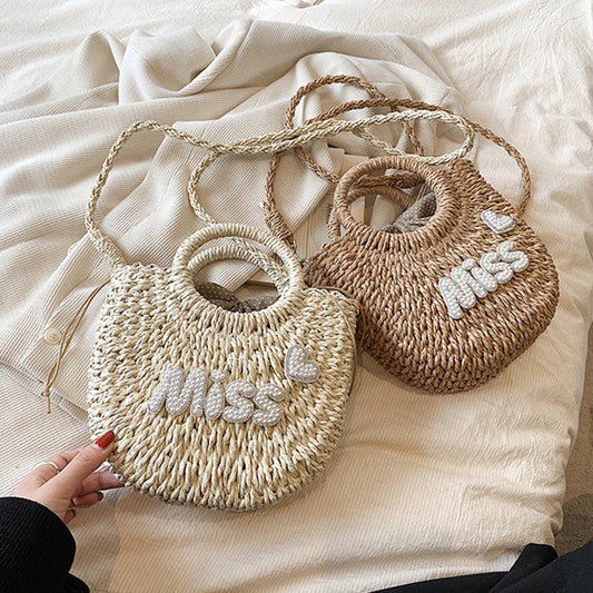 Due borse intrecciate con ricamo 'Miss' su uno sfondo di tessuto beige