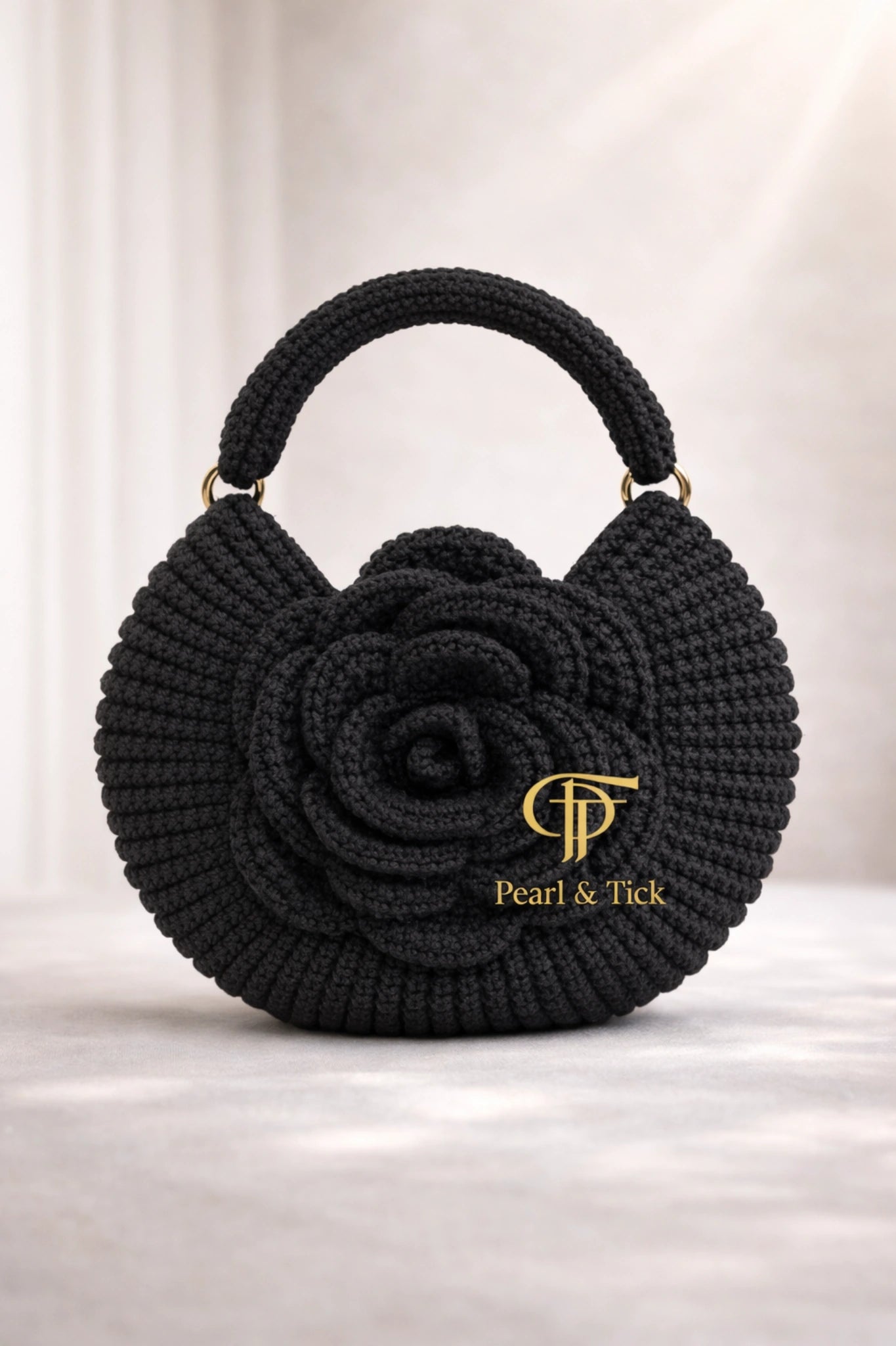 Borsa nera lavorata all'uncinetto con il logo del marchio su sfondo bianco