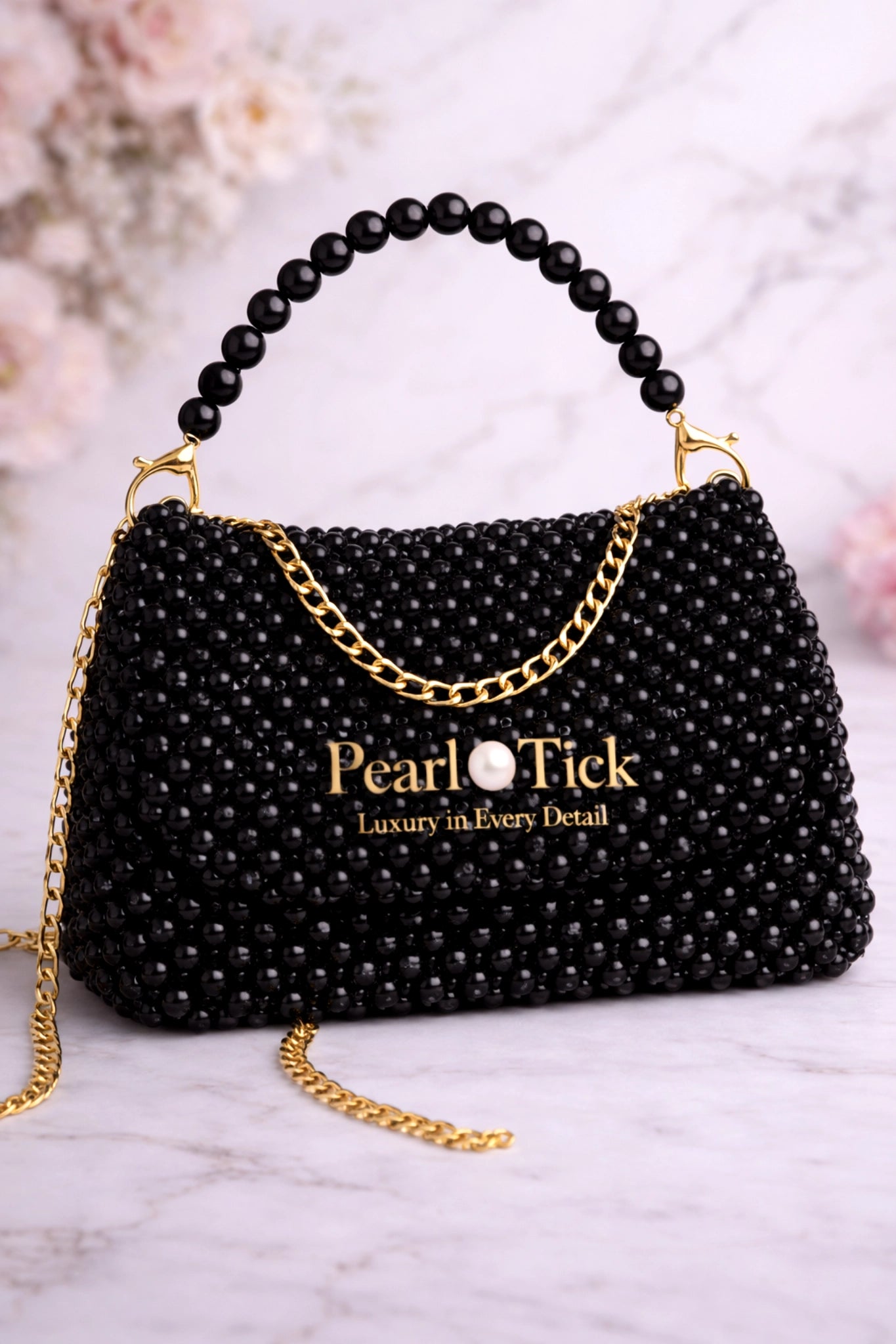 Borsa a mano con perline nere, manico a catena dorata e logo "Pearl Tick" su fondo marmorizzato.