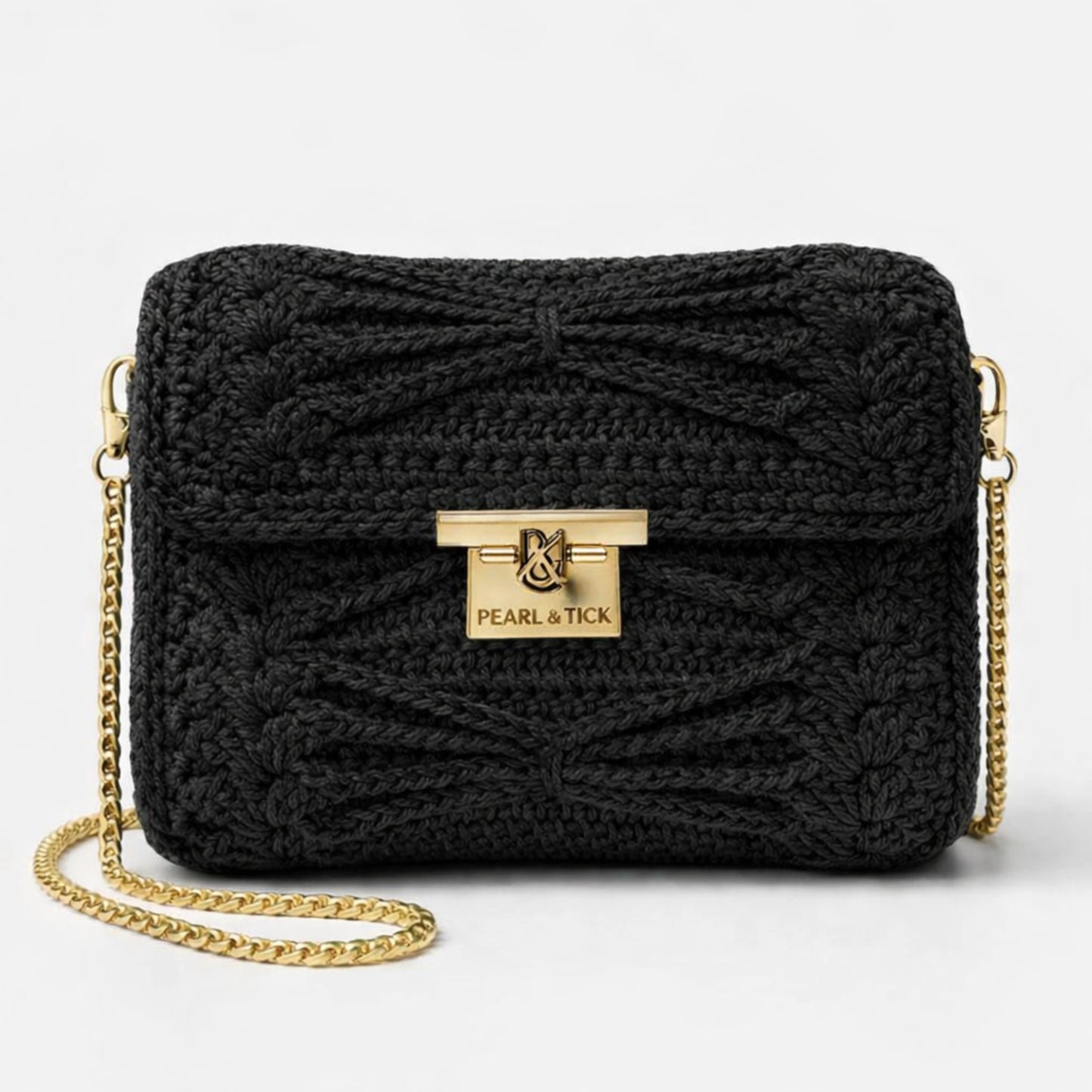 Sac à main tricoté noir avec chaîne dorée et logo de la marque visible sur fond gris clair