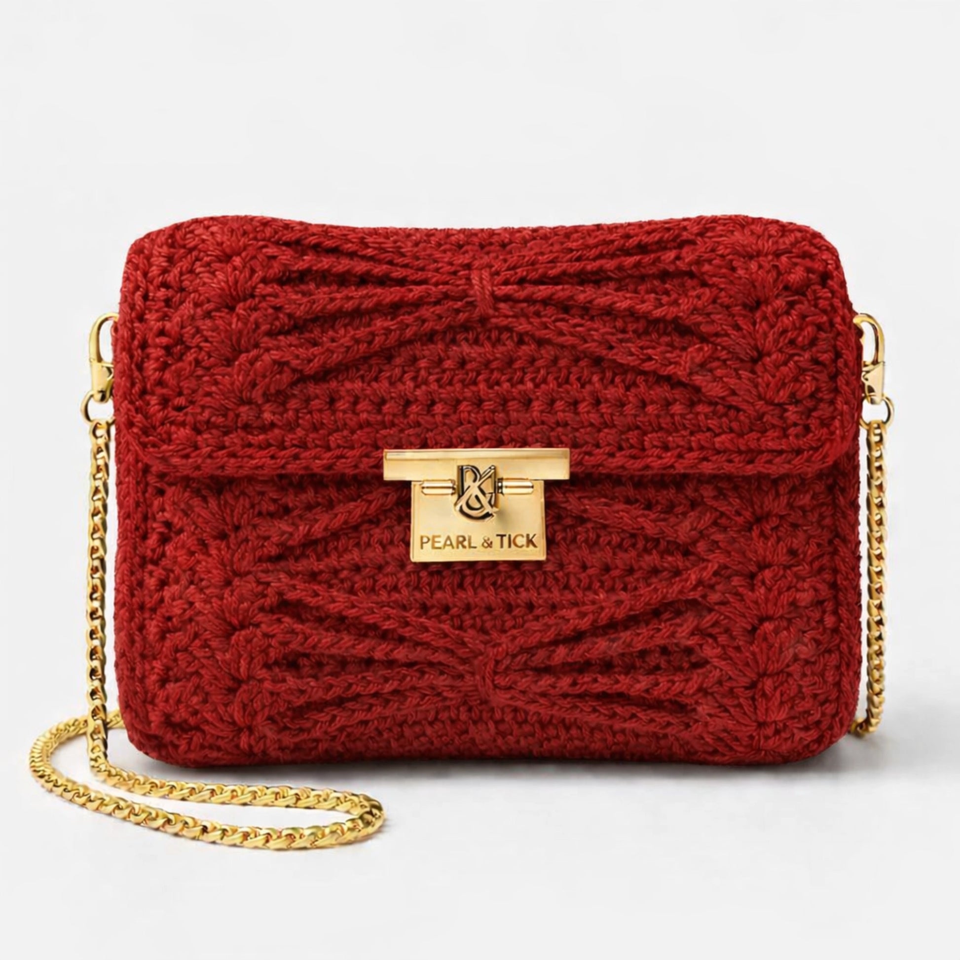 Sac à main tricoté rouge avec chaîne dorée et logo de la marque visible sur fond gris clair