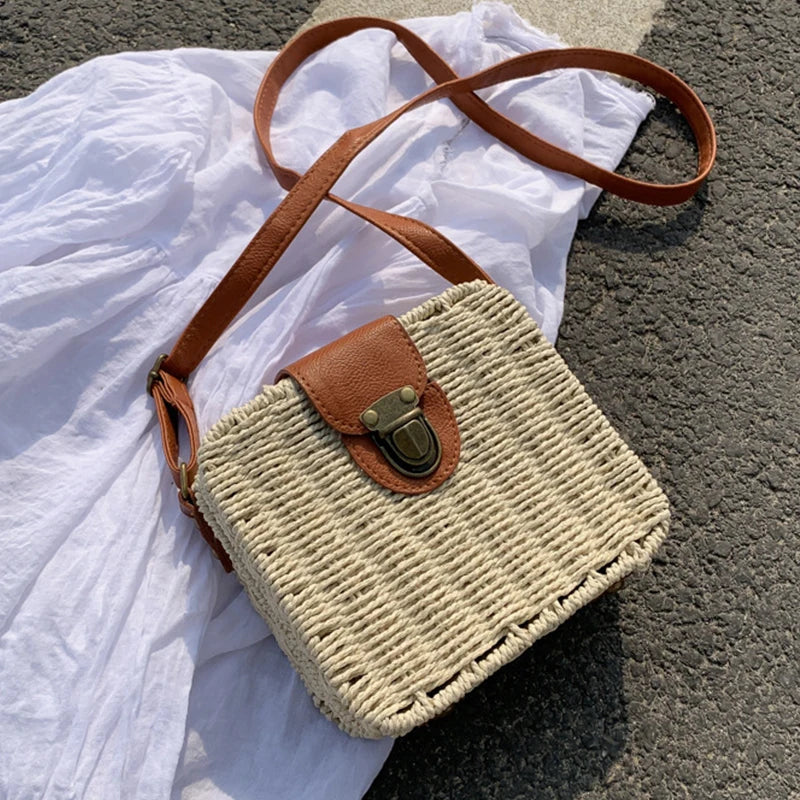 Sac à main tissé avec une sangle marron et une boucle sur un fond de tissu blanc