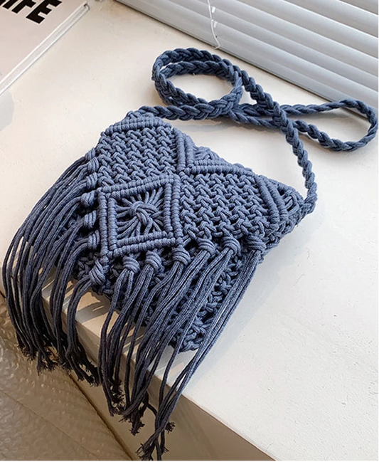 Blue macrame bag with tassels on a light surface