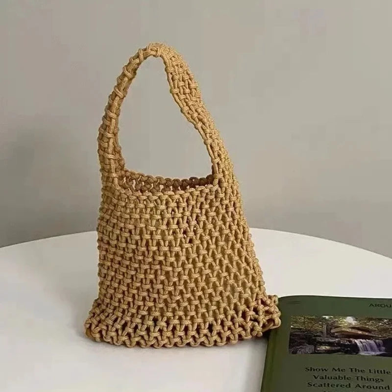 Sac à main tressé beige sur une surface blanche avec un arrière-plan flou