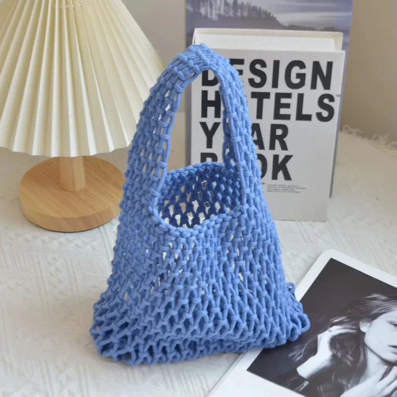 Sac tressé bleu sur une surface avec une lampe et des livres en arrière-plan