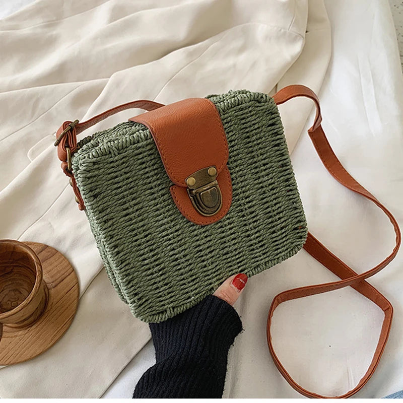 Sac à main tissé vert avec une sangle marron tenu par une main sur un fond de tissu clair