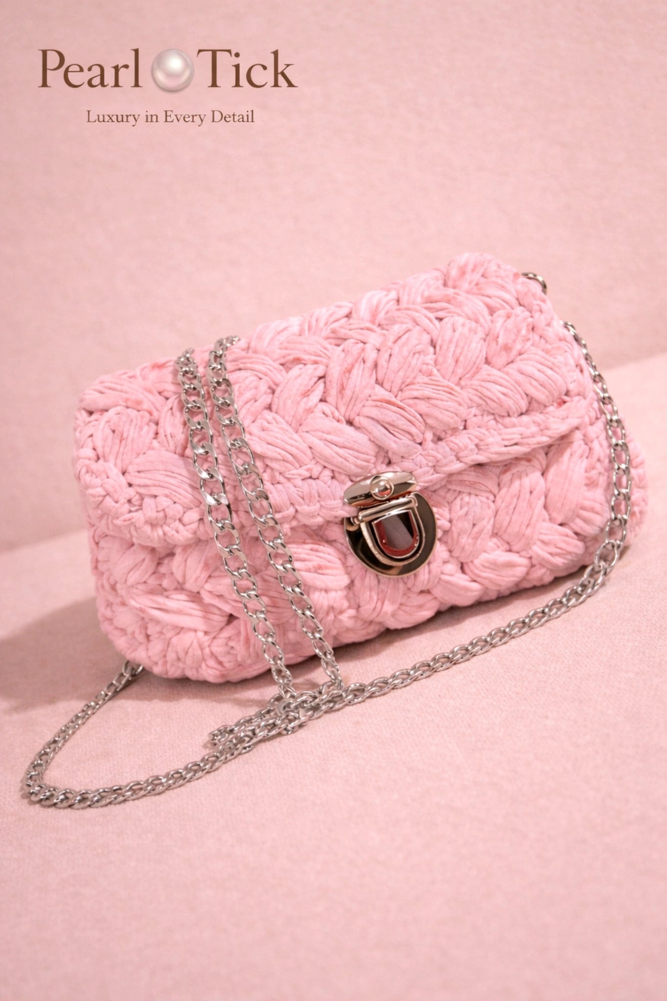 Pink textured handbag with a chain strap on a pink background, featuring the brand 'Pearl Tick'.