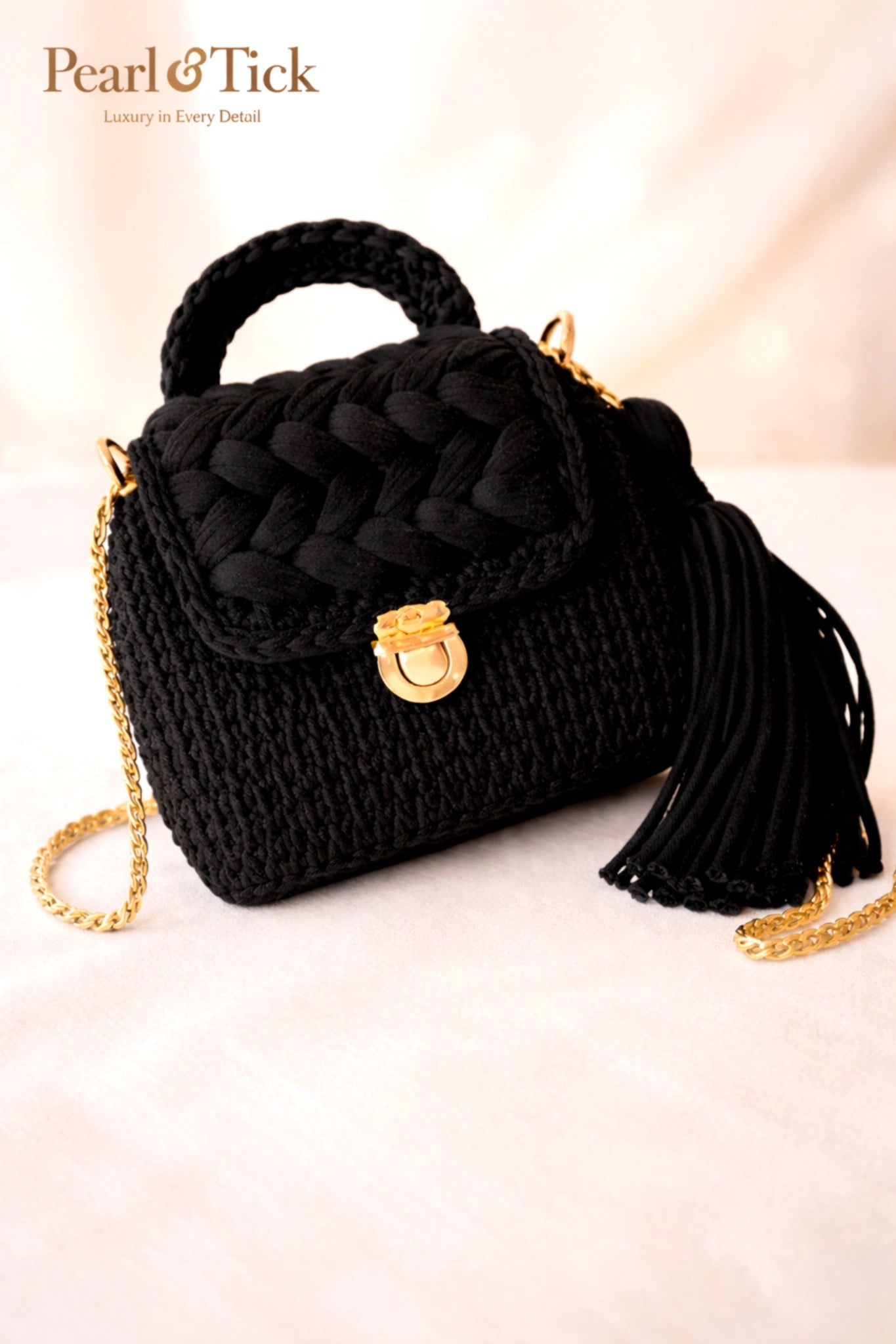 Borsa intrecciata nera con dettagli dorati su sfondo rosa chiaro