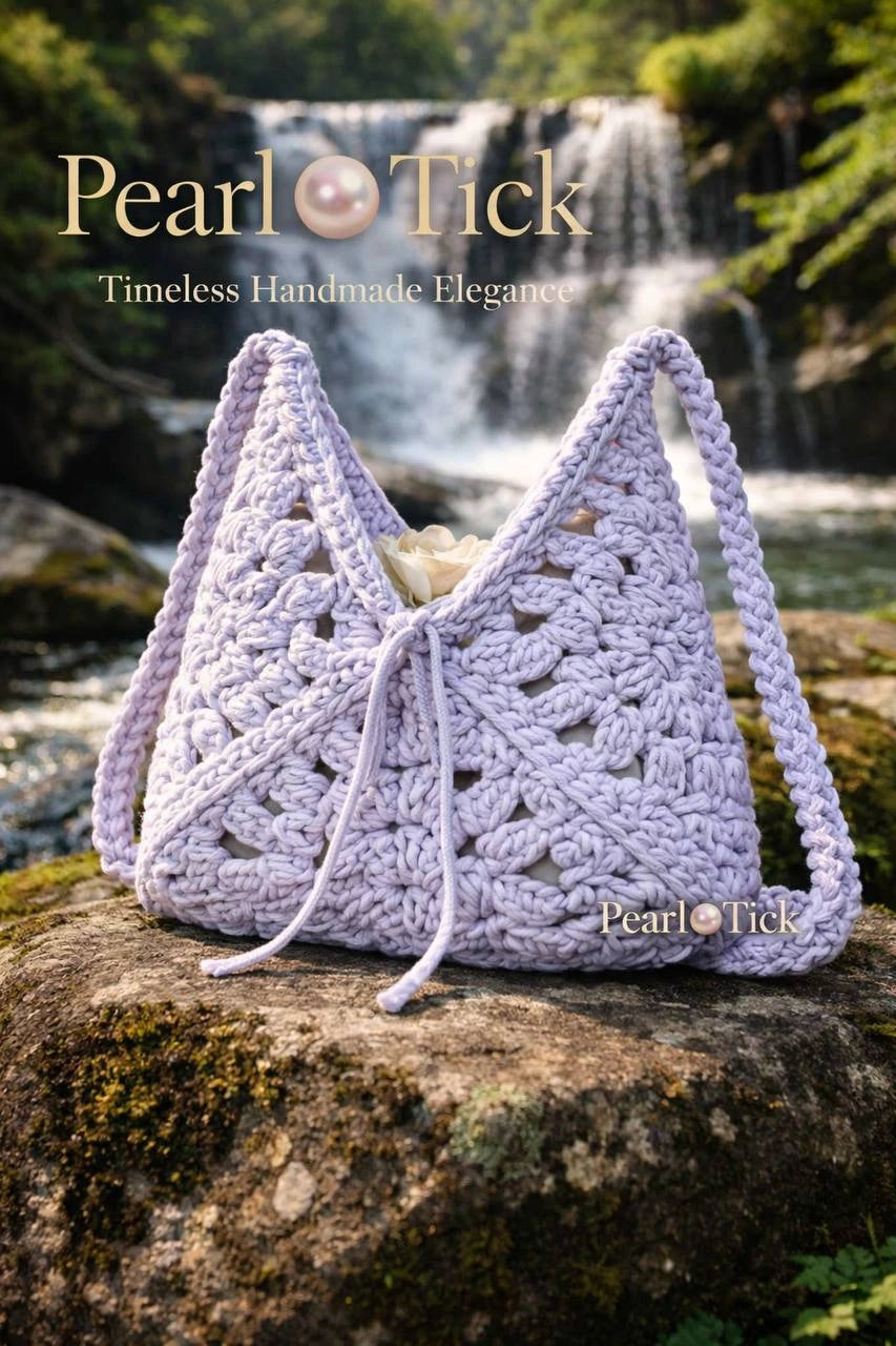 Borsa all'uncinetto realizzata a mano da Pearl Tick su una roccia con una cascata sullo sfondo