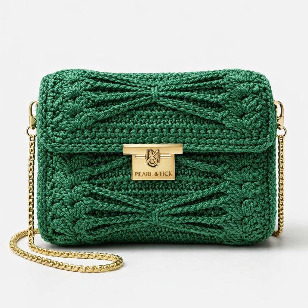 Sac à main tricoté vert avec chaîne dorée et logo 'Pearl & Tick' sur fond gris clair