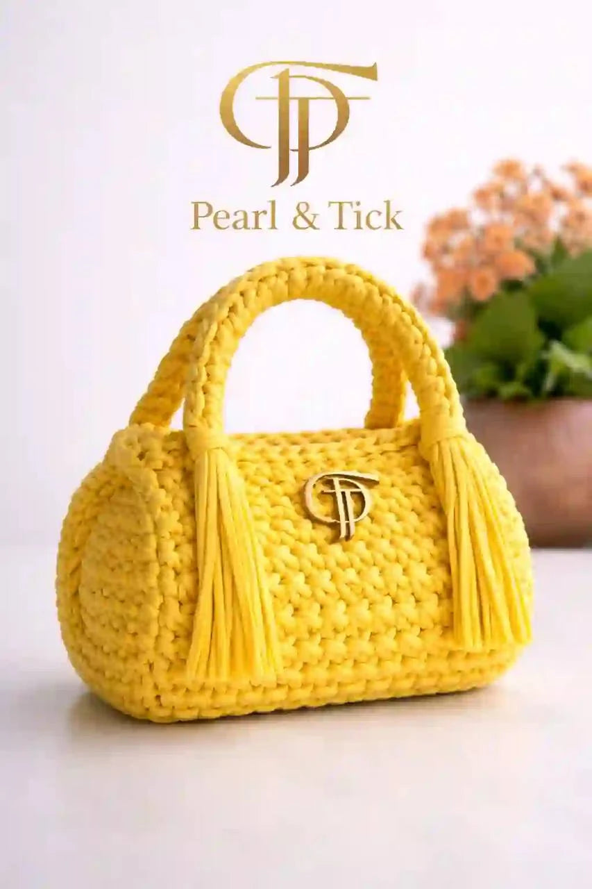 Borsa a mano intrecciata di colore giallo con il marchio «Pearl & Tick» su sfondo chiaro
